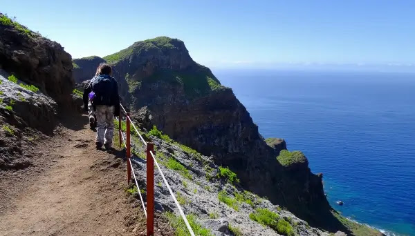 Trilhas com paisagens vulcânicas e o mar azul profundo ao fundo, capturando a serenidade e beleza da Ilha da Madeira.